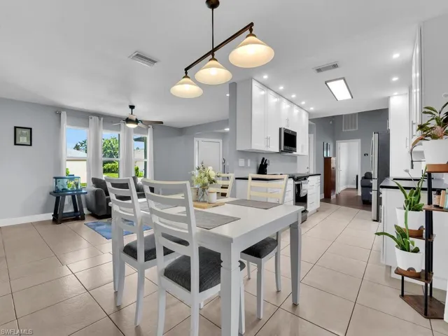 Dining space with light tile patterned floors, ceiling fan, and recessed lighting