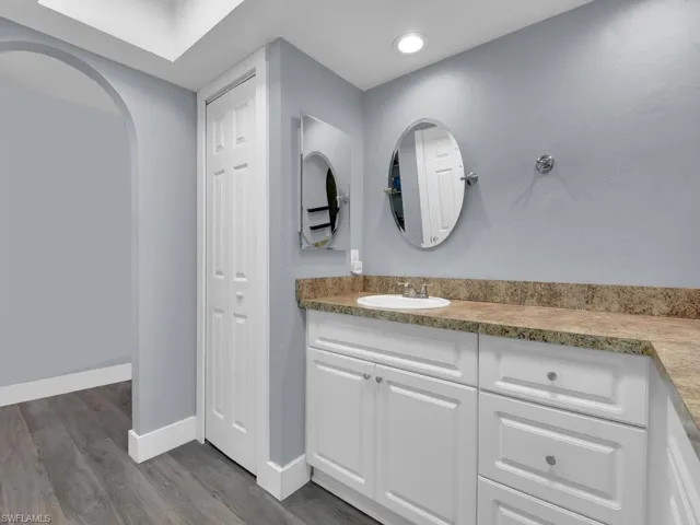 Bathroom with vanity, wood finished floors, and recessed lighting
