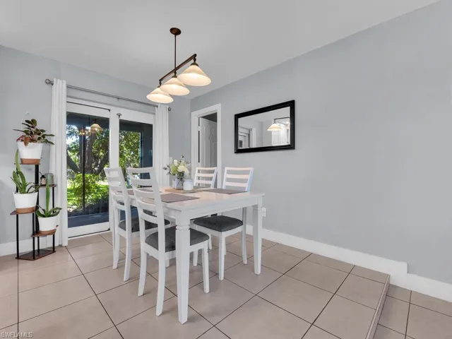 Dining space with light tile patterned floors and baseboards