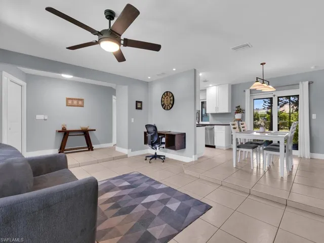 Living room featuring light tile patterned floors, recessed lighting, built in desk, and ceiling fan