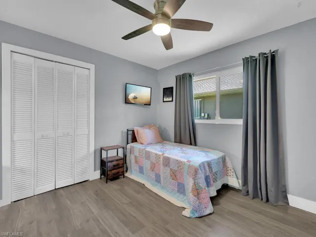Bedroom featuring wood finished floors, a closet, and a ceiling fan