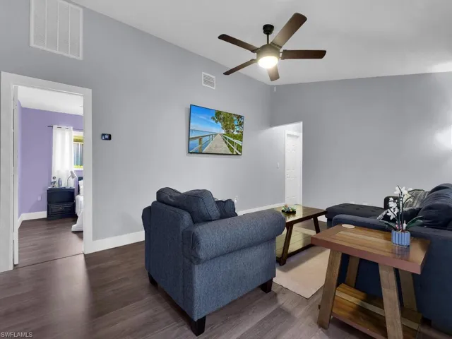 Living room featuring vaulted ceiling, wood finished floors, and ceiling fan
