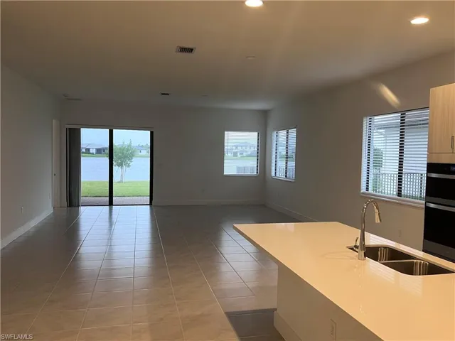 Kitchen featuring sink, light tile patterned floors, and plenty of natural light