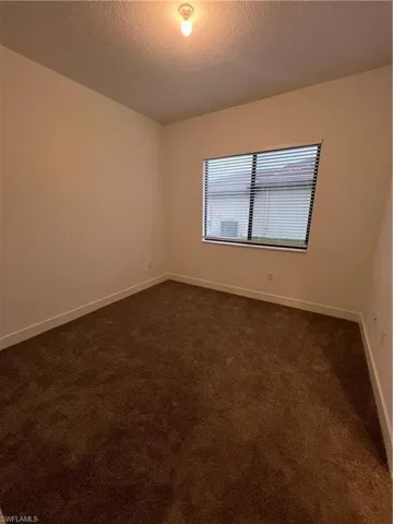 Carpeted spare room featuring a textured ceiling