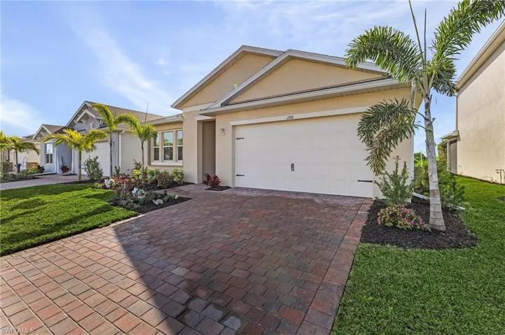 Ranch-style house featuring a garage and a front lawn