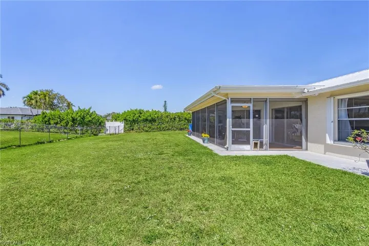 View of yard with a sunroom and fence