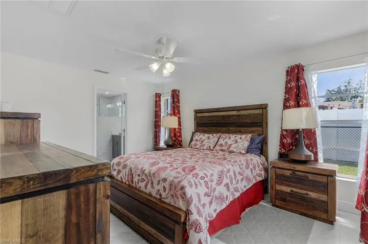 Bedroom with visible vents, ceiling fan, and ensuite bath