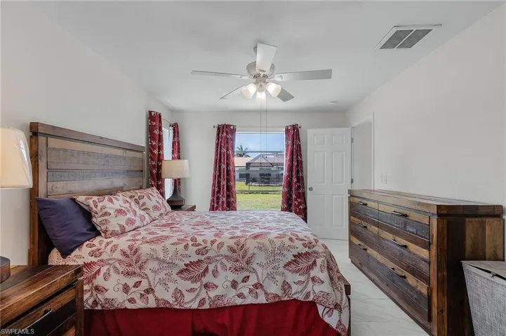 Bedroom featuring marble finish floor, ceiling fan, and visible vents