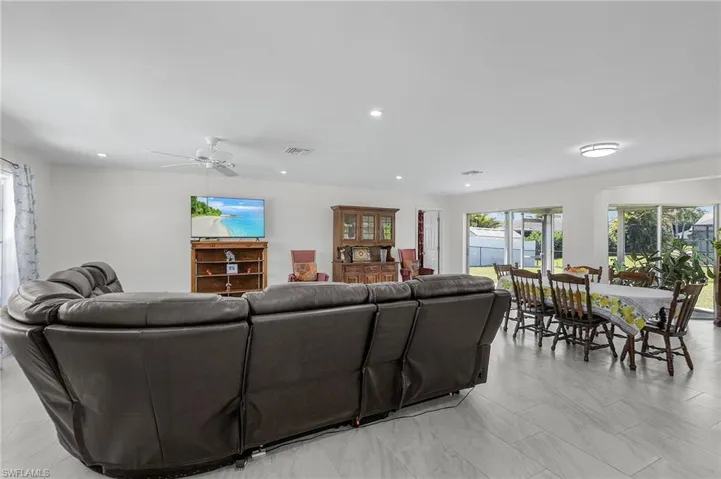 Living area with a ceiling fan, visible vents, and recessed lighting