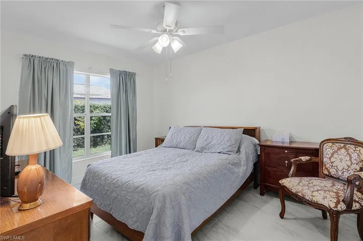 Bedroom with ceiling fan and marble finish floor