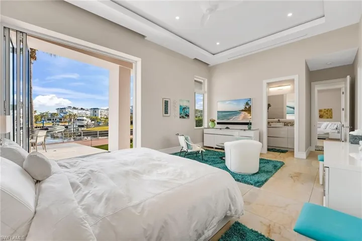 The second bedroom offers direct access to the lanai and features a private ensuite bath, soft cloud lighting, and a spacious walk-in closet, creating a comfortable and well-appointed retreat.
