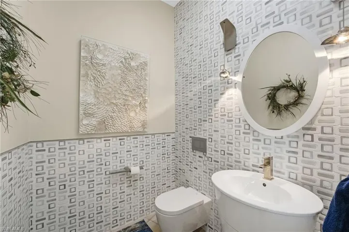 The powder bath showcases stunning custom-designed tilework, offering a refined and visually striking space that elevates everyday luxury.