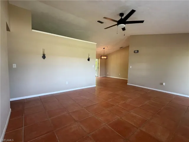 Living Room with view toward dining room and sliding door to lanai.  New ceiling fan and wall sconces have been placed.