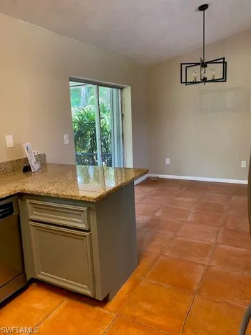 Kitchen with view toward dining area and sliding doors leading to screened lanai.