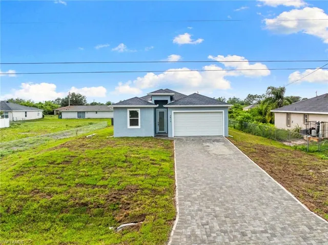 View of front facade with a garage, decorative driveway, stucco siding, and a shingled roof