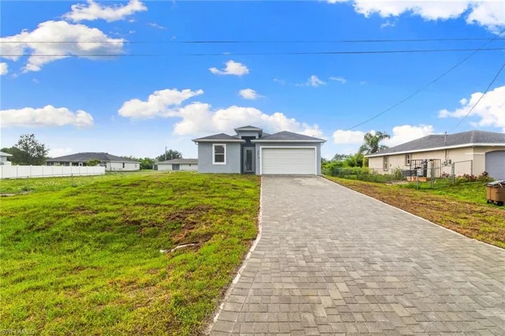 View of front facade with decorative driveway and an attached garage