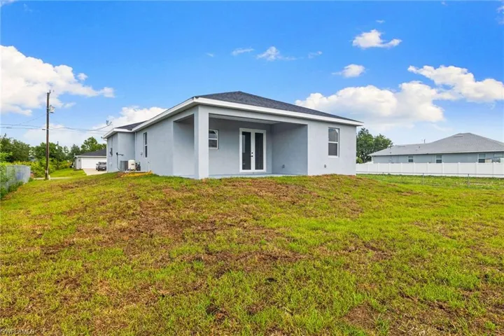 Rear view of house with french doors, stucco siding, and central AC unit