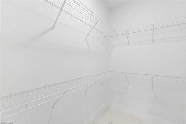 Walk in closet with light marble finish floors