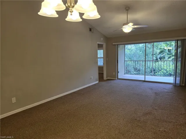 Living/Dining areawith a chandelier, plenty of natural light, lofted ceiling, carpet flooring, and baseboards