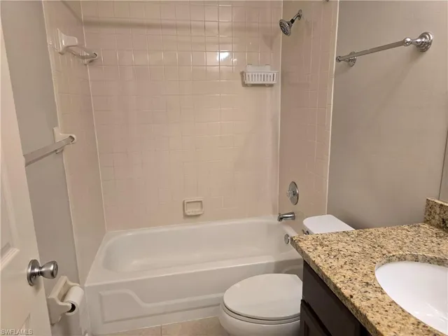 Full bathroom featuring toilet, vanity, and tub / shower combination