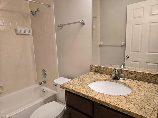 Full bathroom featuring toilet, vanity, and shower / bath combination