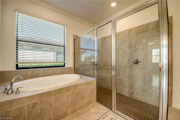 Full bathroom with a garden tub, crown molding, a stall shower, and tile patterned floors