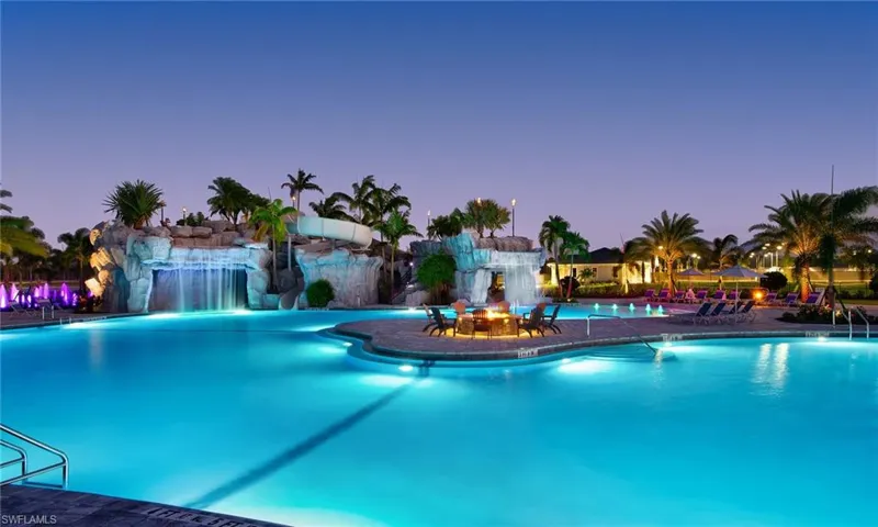 Pool at dusk with a community pool and a patio