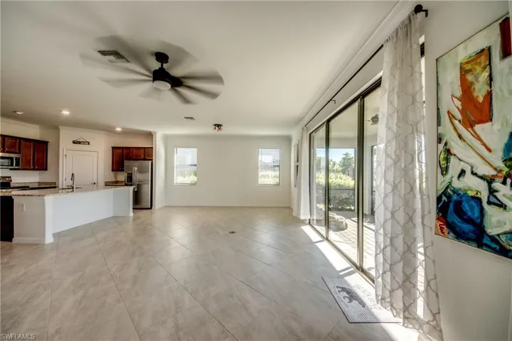 Unfurnished living room featuring a ceiling fan, ornamental molding, recessed lighting, and light tile patterned floors