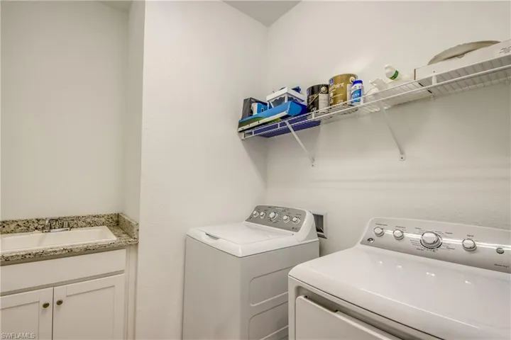 Laundry area featuring washing machine and clothes dryer and a sink