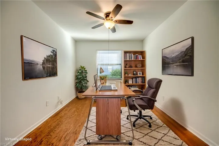 Office area with wood finished floors and ceiling fan