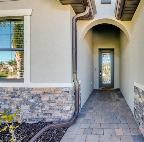 Doorway to property with stucco siding and stone siding