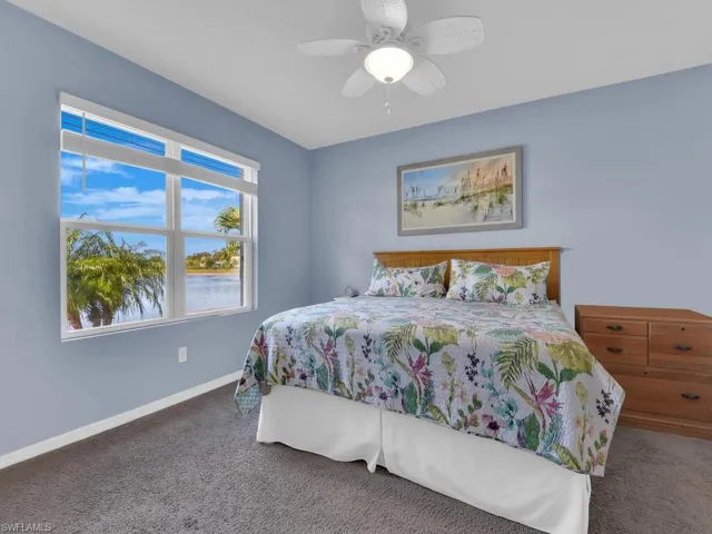 Bedroom with dark colored carpet and ceiling fan