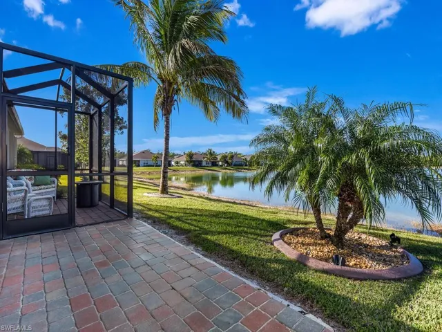 View of patio with a water view and glass enclosure