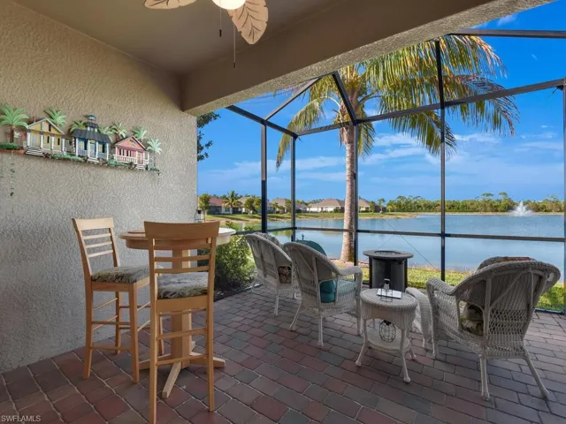 View of patio / terrace featuring ceiling fan, a water view, and glass enclosure