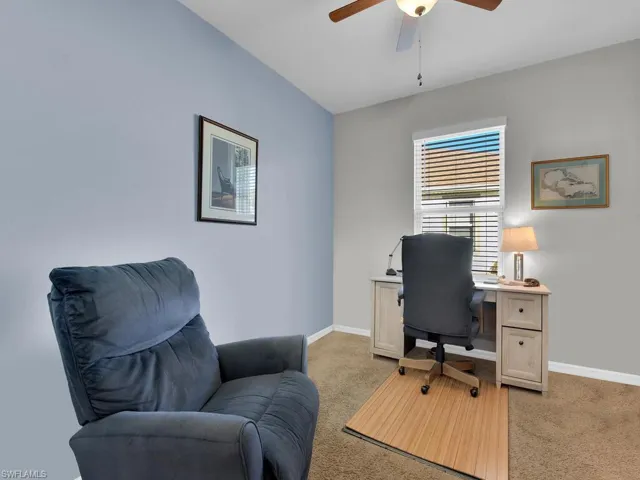 Office with light colored carpet and ceiling fan