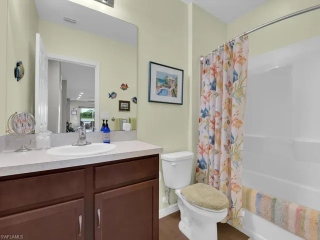 Full bathroom featuring vanity, toilet, and shower / tub combo with curtain