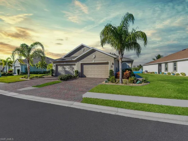 Single story home with a garage and a lawn