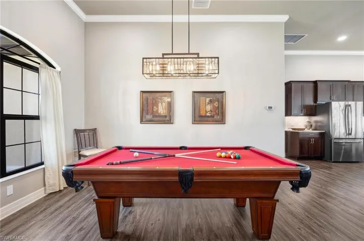 Game room featuring crown molding, hardwood / wood-style flooring, pool table, and a healthy amount of sunlight