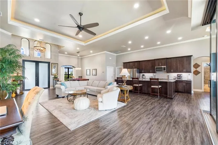 Living room with ceiling fan, french doors, a raised ceiling, and dark hardwood / wood-style floors