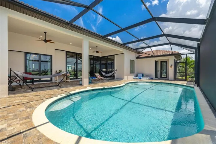 View of pool featuring a lanai, a patio, and ceiling fan