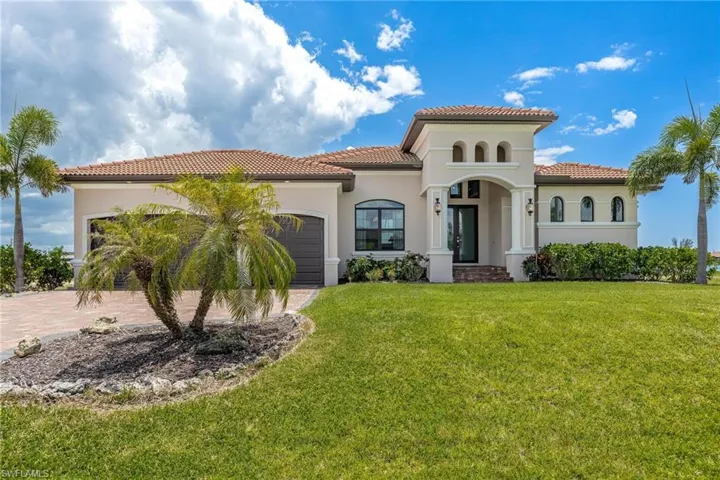 Mediterranean / spanish house with a garage and a front lawn