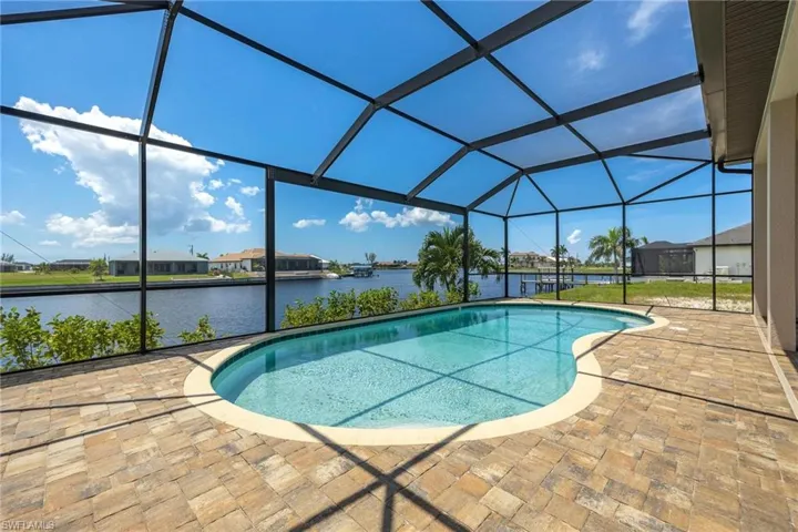 View of pool with a water view, a patio area, and a lanai