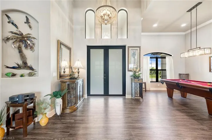 Entryway with crown molding, a towering ceiling, pool table, and dark hardwood / wood-style floors