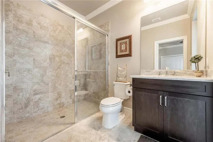 Junior Suite Bathroom featuring pool access, toilet, an enclosed shower, ornamental molding, tile patterned flooring, and vanity