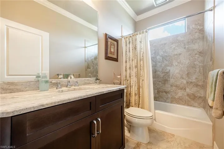 Full bathroom featuring toilet, ornamental molding, tile patterned flooring, shower / tub combo, and vanity