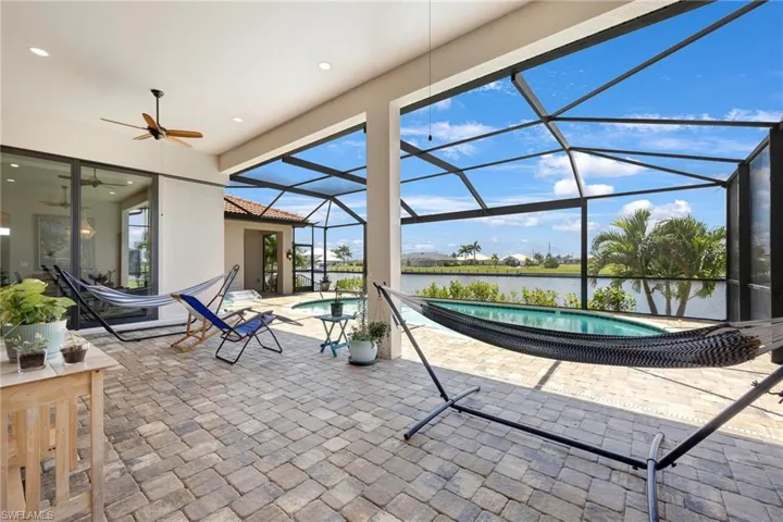 View of patio featuring glass enclosure and ceiling fan