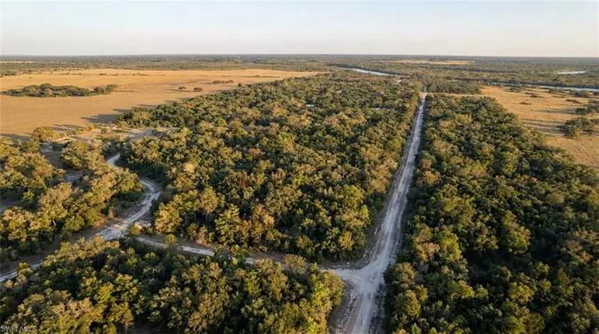 Expansive undeveloped land featuring a combination of dense woodlands and open fields