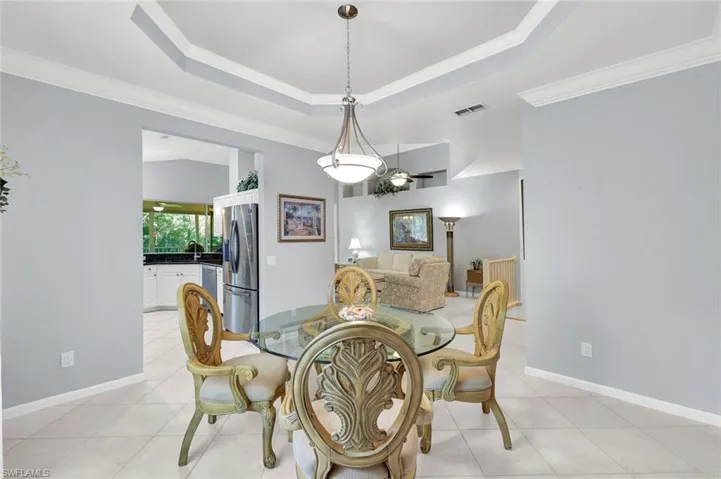 Dining area with easy access to the kitchen and living spaces. Lovely tray ceiling with crown molding detail!