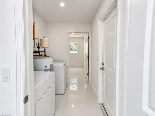 Hallway featuring white panel doors, recessed lighting, and white tile flooring