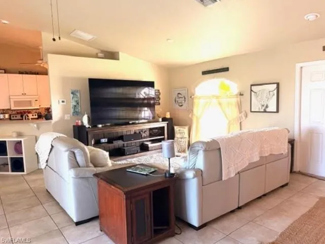 Living area featuring lofted ceiling and light tile patterned floors